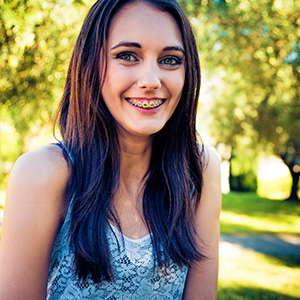 A young girl smiling with braces.